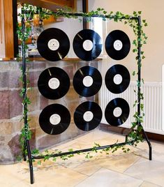 an old record rack is decorated with vinyl records and greenery for the music player's turntables