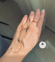 a woman's hand with a ring on it and an artistic design on the wrist