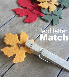 a pair of scissors sitting on top of a wooden table next to cut out leaves