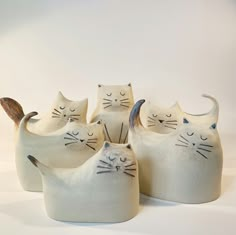 four ceramic cats sitting next to each other