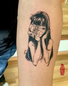 a woman's arm with a black and white tattoo on it