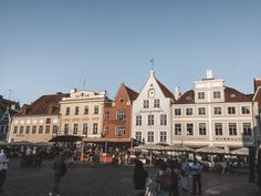 many people are walking around in front of some buildings