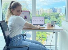 a woman sitting at a desk using a laptop computer