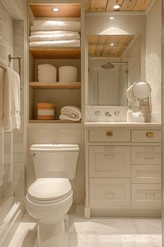 a white toilet sitting in a bathroom next to a walk in closet filled with towels