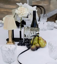 the table is set with wine and fruit