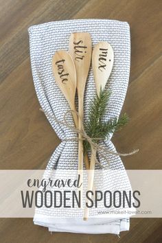 three wooden spoons with names on them are wrapped in a towel and tied together