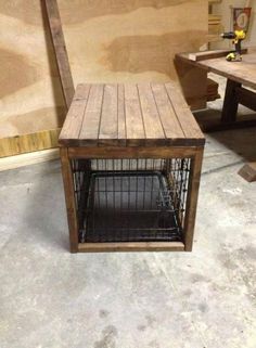 a dog crate sitting on top of a floor next to a wooden table and bench