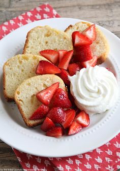 two slices of bread with whipped cream and sliced strawberries on the side in a white plate