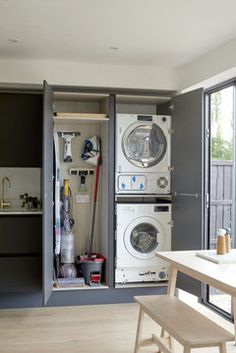 a washer and dryer are in an open cabinet next to the kitchen table