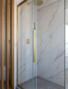 a bathroom with white marble and gold accents