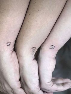 two people holding hands with numbers on their wrists and one has a small tattoo on the wrist