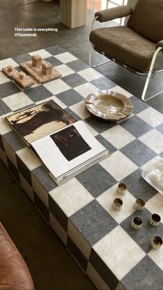 a checkered table with plates and cups on it in a living room or dining area