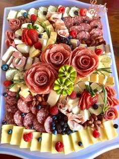 a platter filled with meat, cheese and fruit