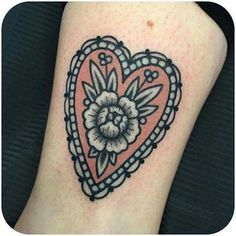 a heart shaped tattoo with a flower on the inside of it's center piece