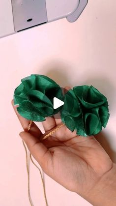 a person is holding two green flowers in their left hand and the other one has a gold ring on it