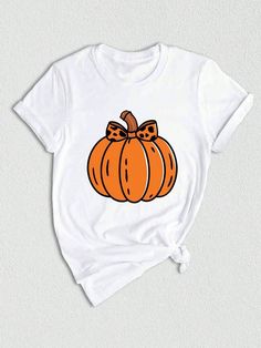 a white t - shirt with an orange pumpkin on the front and bow at the back