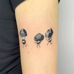 a woman's arm with three small mushrooms on it and one is holding an umbrella