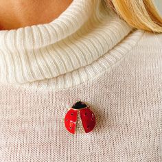 This cute ladybird pin is crafted with enamel and sparkly crystals, offset against gold plating. Ladybird jewelry is a classic motif, and will put a smile on any vintage loving wearer. Try wearing your ladybird brooch with knitwear, for a sparkling touch or with a 1970s broderie anglaise dress for a dreamy style. A vintage inspired piece, this sweet motif is perfect for vintage loving nature fans! Called ladybirds in the UK or ladybugs on the other side of the Atlantic, they represent prosperity, love and luck everywhere! Each ladybird brooch arrives lovingly gift wrapped in tissue, organza gift pouch, and with a gift box, so it's gift ready. Treat yourself or a friend! Measures approximately  2.7 cm wide by 2.6 cm long Red Enamel Brooch Pin For Gift, Red Enamel Brooch, Red Enamel Brooches As Gift, Red Enamel Brooch Pin, Red Enamel Brooches For Gift, Red Enamel Brooch Gift, Red Enamel Brooch For Gift, Red Enamel Brooch Jewelry, Red Enamel Pin As Gift