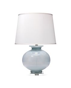 a blue glass table lamp with a white shade on the top and bottom part of it