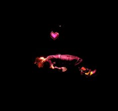 two people are floating in the dark with hearts above them