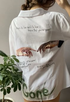 the back of a woman's white shirt with hands on it and writing that says,