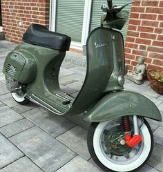 a green scooter is parked on the sidewalk