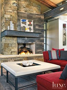 a living room filled with furniture and a fire place in the middle of it's wall