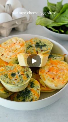 a bowl filled with egg muffins next to some spinach leaves and eggs