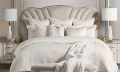 a bed with white linens and pillows in a luxurious bedroom setting that is well decorated