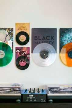 three turntables are sitting next to two record players and some posters on the wall