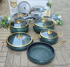 green speckled pots and pans sitting on the ground next to a cookbook