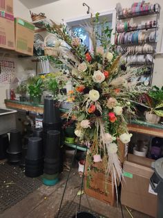 an arrangement of flowers is on display in a flower shop, with other items nearby