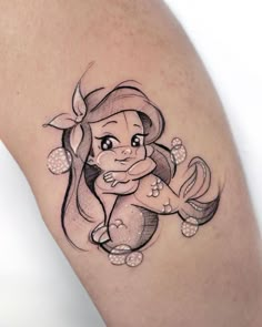 a woman's leg with a tattoo on it that has an image of a little mermaid