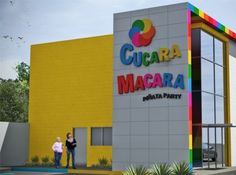 two people standing in front of a building with the words gugara macara on it