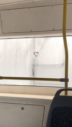 there is a heart drawn on the window of a bus with no people around it