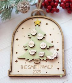 a wooden ornament with a christmas tree on it and the words, the smith family