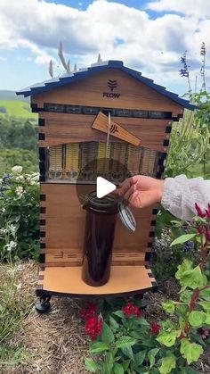 a beehive with a person holding a glass in front of it