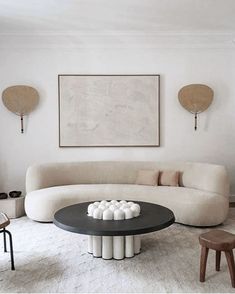 a living room filled with furniture next to a painting on the wall above a coffee table