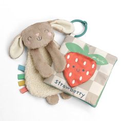 a stuffed animal sitting next to a book with a strawberry on it's cover