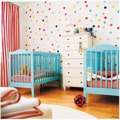 two baby cribs in a child's room with polka dot wallpaper