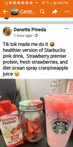 the starbucks drink is next to some strawberries in a jar and on top of a table