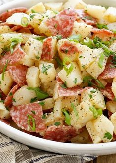 a white bowl filled with potatoes and meat