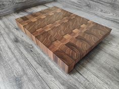 a wooden cutting board sitting on top of a hard wood floor