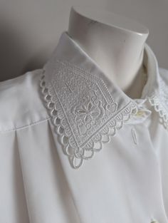 ⭐Description⭐ I'm all about classic blouses with fun details and this blouse definitely delivers.  Cute embroidery details on the collar. Pleated and the neckline with short sleeves ⭐Condition ⭐ Excellent condition. ⭐Measurements taken flat⭐ Pit to pit - 23" shoulder to shoulder - 19" length - 27" ⭐THANK YOU⭐ I am one woman on a mission to find beauty in discarded treasures and make sure they go to good homes where they will be used for years to come! ⭐NOTE⭐ Some of my pieces may show minor wear White Embroidered Blouse With Peter Pan Collar, White Collared Tops With Embellished Collar, White Collared Top With Embellished Collar, Classic Collared Tops With Floral Embroidery, Classic Collared Top With Floral Embroidery, Embroidered Summer Blouse With Collared Neckline, White Blouse With Floral Embroidery And Peter Pan Collar, Vintage Lace Collar Button-up Top, Classic Embroidered Collared Tops