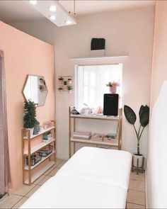 a bedroom with pink walls and white furniture