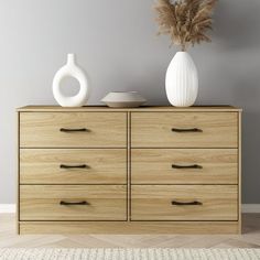 a white vase sitting on top of a wooden dresser