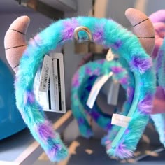 a blue and purple furry animal steering wheel cover with tags attached to it's ears