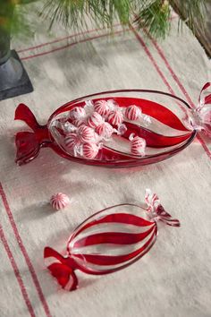 a glass bowl filled with candy canes on top of a table