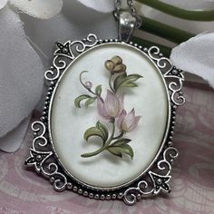 Enhance your jewelry collection with this beautiful vintage hand-painted tulips pendant necklace. The pendant is crafted from silver and adorned with rare enamel, giving it a unique antique look. The size of the pendant is large enough to make a statement, yet not too overwhelming. This necklace is a perfect addition to any outfit, whether it is casual or formal. The intricate details of the tulips and the delicate chain make this piece stand out. It is a rare find that is sure to be cherished for years to come. 30x40mm on the center frosted cabochon  24 inch chain (I added that ) SEE OUR STORE FOR MANY MANY DIFFERENT TYPES OF GIFTS  WE ALSO CARRY BOLO TIESCAMEO JEWELRYWESTERN JEWELRYWESTERN WEARANTIQUESPRECIOUS MOMENTSVINTAGE FISHING LURESVINTAGE HARLEY PARTSVINTAGE MOTORCYCLE PARTSMEMORO Painted Tulips, Victorian Colors, Types Of Gifts, Necklace Antique, Delicate Chain, Unique Antiques, Silver Pendant Necklace, Womens Jewelry Necklace, Silver Pendant