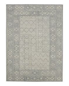 a gray rug with an intricate design on the front and back side, in grey tones